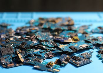Pile of disassembled circuit boards on a blue surface. Perfect for tech themes.