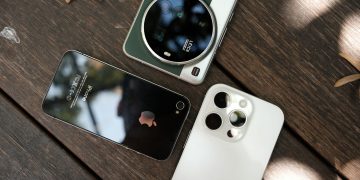 Overhead composition of multiple smartphones on a wooden surface, highlighting contemporary technology.