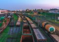 Aerial view of Minsk railway station with tracks and freight trains at dusk, highlighting transportation infrastructure.