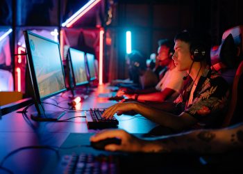 Group of gamers immersed in competitive esports at a cyber arena with neon lighting.