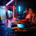 Group of gamers immersed in competitive esports at a cyber arena with neon lighting.