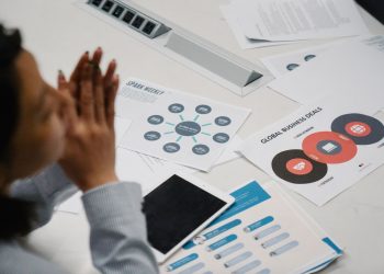 Businesswoman reviewing charts and documents during a professional meeting in an office setting.