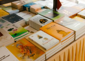 A diverse collection of books neatly arranged on a table indoors.