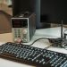 A high-tech desktop setup featuring a power programmer, computer keyboard, and monitor