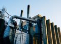 Low angle exterior of factory located on city street under blue sky in evening time