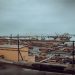 View of Tema Port in Ghana featuring shipping containers and cranes under a cloudy sky.