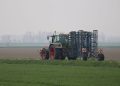A tractor working on agricultural land during an overcast day, depicting modern farming practices.