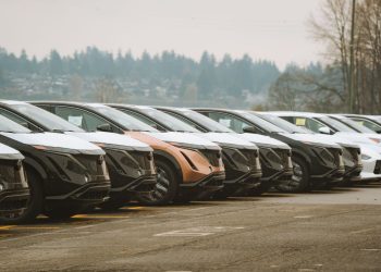 Rows of sleek electric cars parked outdoors, showcasing automotive design and innovation.