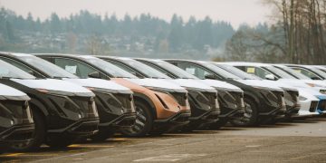 Rows of sleek electric cars parked outdoors, showcasing automotive design and innovation.