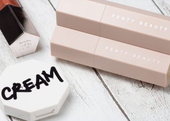 Stylish arrangement featuring beauty products on a wooden background, showcasing elegant packaging.