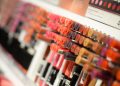 Close-up of diverse lipsticks in a store showcasing various shades and brands for beauty enthusiasts.
