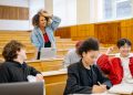 Students in a university lecture hall interacting and studying together.