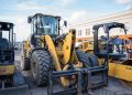 Front view of heavy construction machinery parked in an urban area.