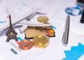 A travel finance concept featuring cryptocurrency, credit card, airplane model, and Eiffel Tower on financial documents.