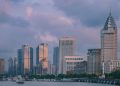 View of Shanghai's modern skyline at twilight with tall skyscrapers and vibrant clouds.