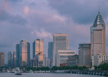 View of Shanghai's modern skyline at twilight with tall skyscrapers and vibrant clouds.