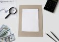 Flat lay of financial tools and blank paper for planning or mockup.