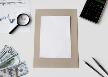 Flat lay of financial tools and blank paper for planning or mockup.