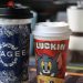Two colorful branded coffee cups with distinct designs, indoors setting.
