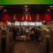 A bustling scene at a McDonald's restaurant counter with customers and staff in an indoor setting.