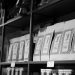 A monochrome image of coffee bags neatly arranged on a store shelf, creating an organized display.