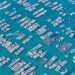 Aerial photo capturing extensive fish farms with grid-like structures in deep blue waters.
