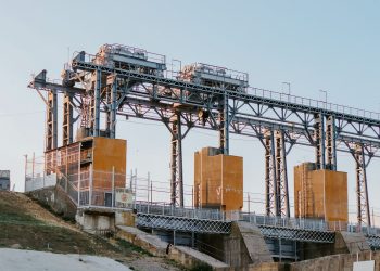 A large industrial hydroelectric facility captured in the serene light of sunset.