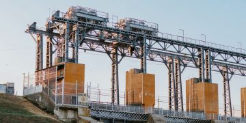 A large industrial hydroelectric facility captured in the serene light of sunset.