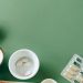 A flat lay of assorted pills and herbs on a green background emphasizing natural health remedies.