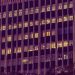 Illuminated urban office building facade at night in New Delhi, showcasing modern architecture with glowing windows.