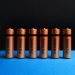 A lined up set of AA batteries with black and blue background.