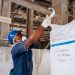 Industrial worker checking a large soda ash bag in a manufacturing facility.