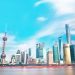 Stunning view of Shanghai skyline with the iconic Oriental Pearl Tower and modern skyscrapers under a bright blue sky.