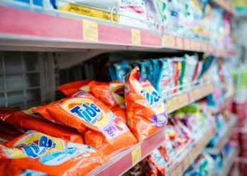 Vibrant selection of laundry detergents on a supermarket shelf, showcasing brands and variety.