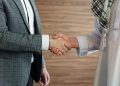 Close-up of a handshake between two men in business attire, symbolizing cooperation and partnership.
