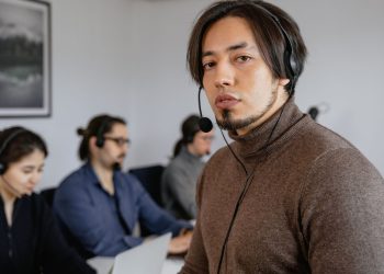 Focused call center team working attentively with headsets on in office.