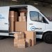 Delivery van loaded with cardboard boxes for global shipping logistics.
