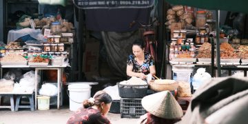 A vibrant market scene in Southeast Asia featuring vendors and local produce.
