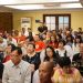 A diverse group of adults attending a conference in an Indonesian indoor setting.