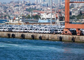 A large shipment of white cars at a bustling port in İstanbul, Türkiye.