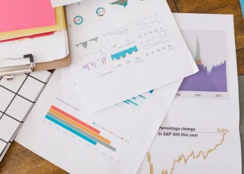 Close-up of business analytics charts and graphs on papers and clipboard.