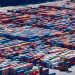 A bustling port with colorful cargo containers, aerial view showcasing global trade.
