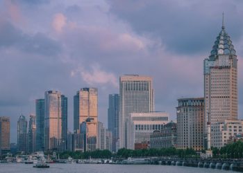 View of Shanghai's modern skyline at twilight with tall skyscrapers and vibrant clouds.