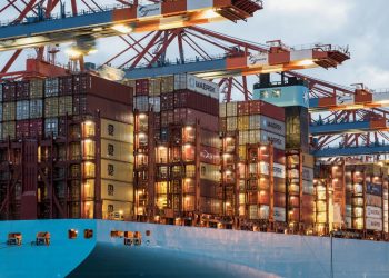 A vibrant cargo ship loaded with containers at Hamburg harbor, showcasing maritime industry.