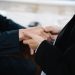 Close-up of two individuals in suits shaking hands, symbolizing business cooperation.