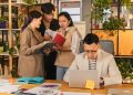 Group of young professionals collaborating in a modern, plant-filled office.