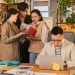 Group of young professionals collaborating in a modern, plant-filled office.