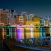 A stunning view of Dubai's illuminated skyline at night with colorful reflections on the waterfront.