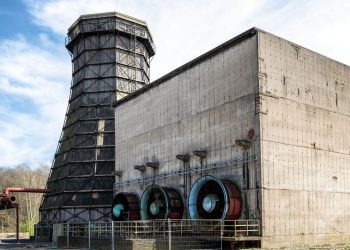 Abandoned industrial site in Essen, featuring a cooling tower and large fans.