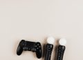 Black gaming controllers arranged on a light background with ample copy space.